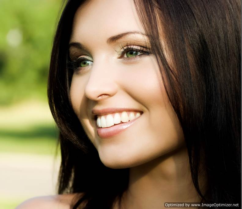 Sideview headshot of female model with a large bright smile