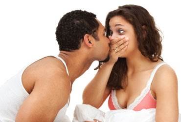 Woman covering her mouth as husband tries to kiss her