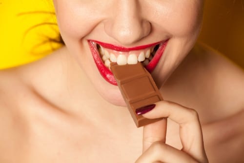 young beautiful woman eating a chocolate