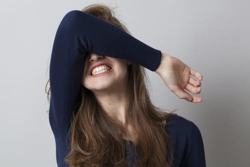 shocked young woman hiding her face with her arm,grinding teeth-img-blog