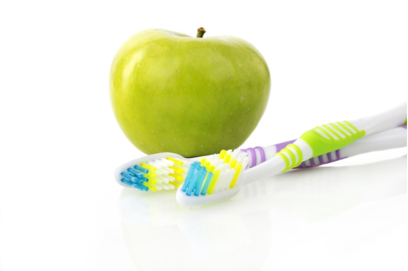 Green apple and two toothbrushes